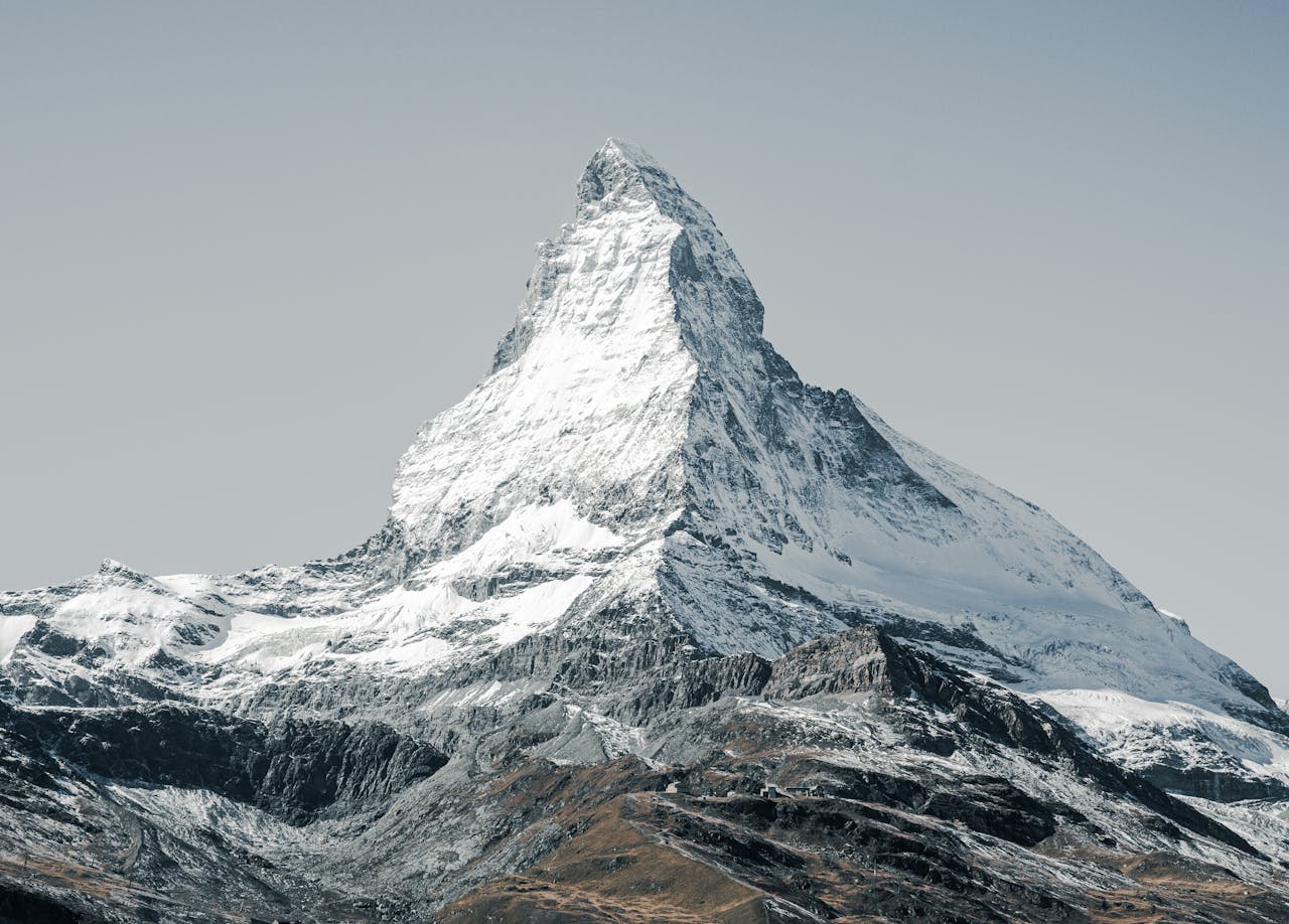 our-story-02 Breathtaking photograph of the Matterhorn under a clear sky, capturing its iconic snow-capped peak.